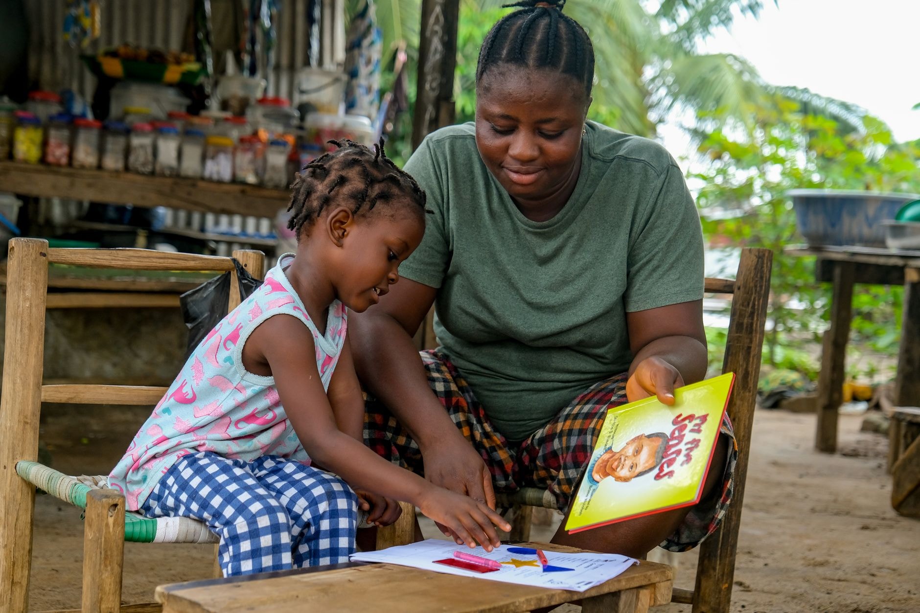Une mère encourage son enfant qui lit à la maison