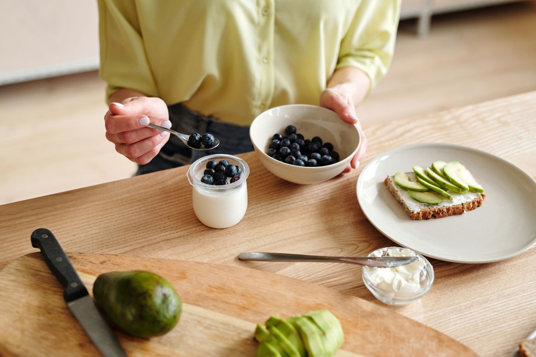 Pain, fruits frais et yaourt disposés sur une table pour un goûter équilibré