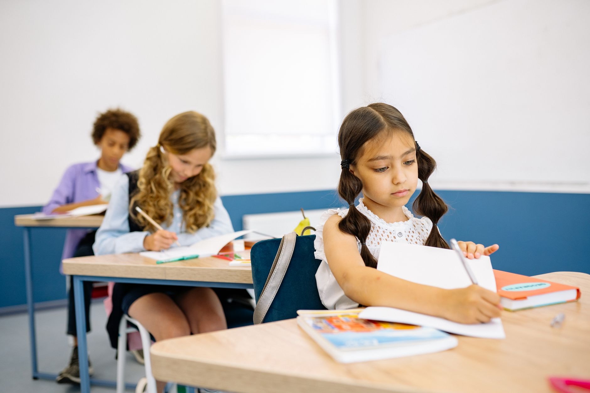 Cahiers d'écolier ouverts sur une table de classe de primaire