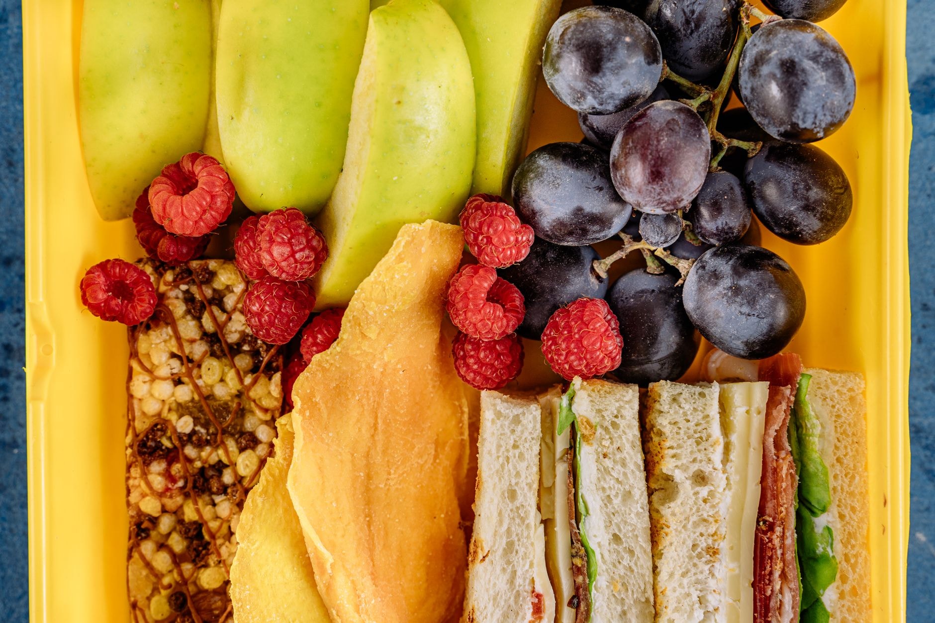 Une boîte à goûter garnie de pain, de fruits et de fromage